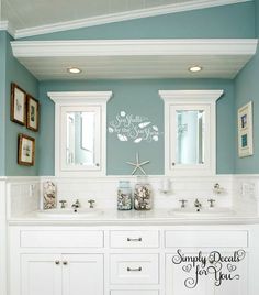 a bathroom with blue walls and white cabinets