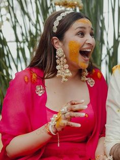 a man and woman sitting next to each other with orange paint on their faces,