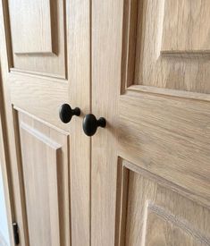 a close up of a wooden door with two knobs