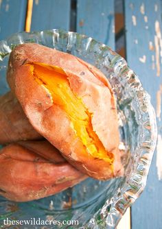 two sweet potatoes sitting on top of a glass plate