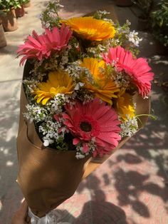 a bouquet of flowers is wrapped in brown paper