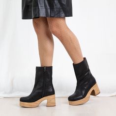 This sleek, simple design features a cushioned chunky clog base for ultimate comfort. The black cracked leather adds a touch of sophistication and texture, making the Bobbie an elegant yet edgy choice for versatile wear. Step confidently in style and comfort with this standout clog boot.Ethically made in Portugal, designed in Sweden. Heel height 8 cm/ 3.14 in Shaft height 19 cm/ 7.5 in shaft circumference 28 cm 11 in True to size Modern Leather Platform Boots With Stacked Heel, Modern Leather Platform Boots With Block Heel, Modern Black Clogs With Leather Sole, Trendy Leather Clogs With Chunky Platform, Chic Medium Width Leather Clogs, Modern Black Platform Boots, Chic Leather Clogs Medium Width, Modern Black Round Toe Clogs, Leather Clogs With Chunky Platform And Round Toe