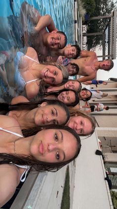 a group of young women standing next to each other in front of a swimming pool