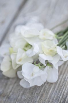 some white flowers sitting on top of a wooden table