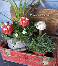 an old wooden box filled with potted plants next to a mushroom shaped planter