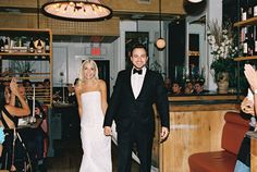 a bride and groom are walking down the aisle at their wedding reception in a restaurant