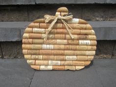 a pumpkin made out of wine corks on the sidewalk