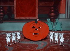 a group of mice standing next to a pumpkin