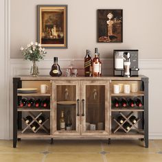 a wooden cabinet with wine bottles and glasses on it in front of a wall mounted painting