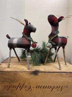 two wooden reindeer figurines sitting on top of a box