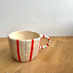 a red, white and blue striped cup sitting on top of a wooden table