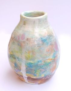 a colorful vase sitting on top of a white table