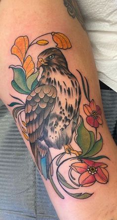 a bird on the arm with flowers around it