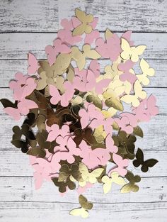 some pink and gold hearts on a white wooden surface