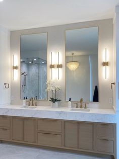 a bathroom with two sinks and three mirrors