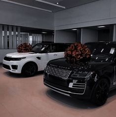 two black and white range rovers with bows on them in a parking garage next to each other