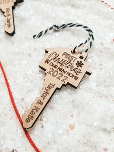 a wooden ornament with the words first christmas from home on it and a red string