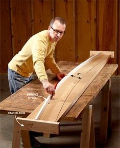 a man sanding down a wooden table with a saw