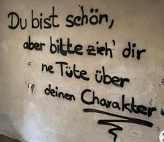 graffiti written on the side of a wall with words in german and english, along with an image of a man's face