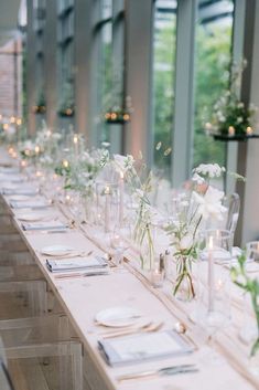 the long table is set with white flowers and candles