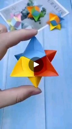 someone is holding an origami star in their hand and it looks like they are flying through the air