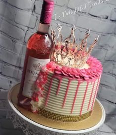 there is a cake with pink icing and a bottle of wine