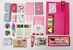 various stationery items are laid out on a white surface, including notebooks and pens