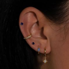 a close up of a person with ear piercings and an earring in the shape of a star