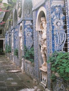 an artisticly decorated building with blue and white tiles on the outside, including statues