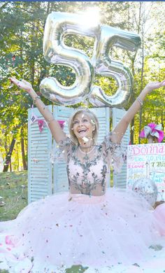 a woman in a tutu and dress with balloons