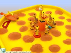 a yellow play table with giraffes on it