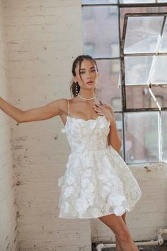 a woman in a white dress is posing for the camera