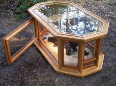 a wooden table with a glass top on the ground