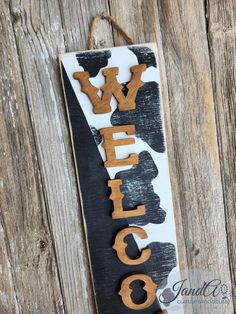 a sign that says welcome hanging on a wooden wall