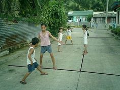 four children playing with a ball in the street