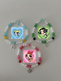 three beaded bracelets with cartoon characters on them and beads hanging from the sides