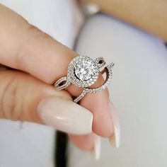 a woman's hand holding a diamond ring