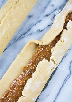 two long breads sitting on top of a marble countertop next to each other