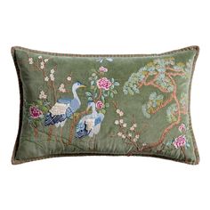 a green pillow with two birds and flowers on the front, sitting on a white background