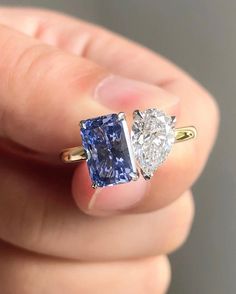 someone is holding two different colored diamonds in their hand, one blue and the other white