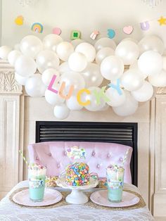 a table topped with lots of balloons and cake