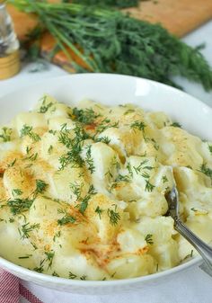 a white bowl filled with potato salad on top of a table