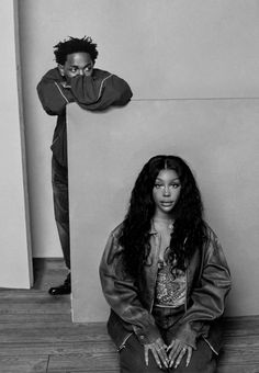 a black and white photo of a woman sitting on the floor next to a man