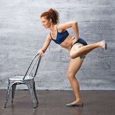 a woman in a blue top is leaning on a metal chair and stretching her legs