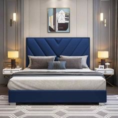 a bed with blue upholstered headboard and two lamps on either side of it