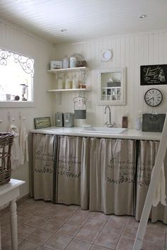 a kitchen with white walls and tile flooring next to a ladder in front of the sink