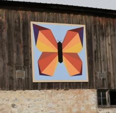 an image of a colorful butterfly on the side of a wooden building with two windows