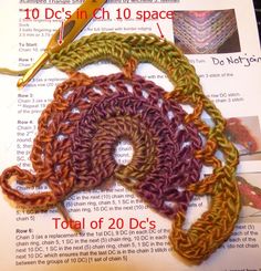 crochet is shown on top of an open book with scissors and thread in it