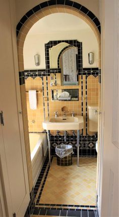 a bathroom with a sink, mirror and bathtub in the doorway to another room