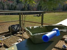 an empty plastic container sitting on top of a green table in the middle of a field